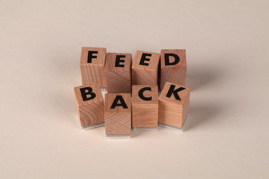 Wooden blocks arranged to spell 'Feedback' on a neutral beige background.